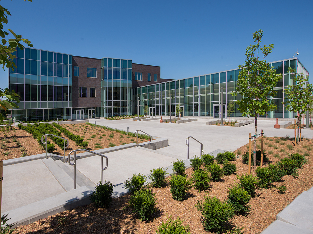 Exterior shot of glass and brick building with large foreground plaza.